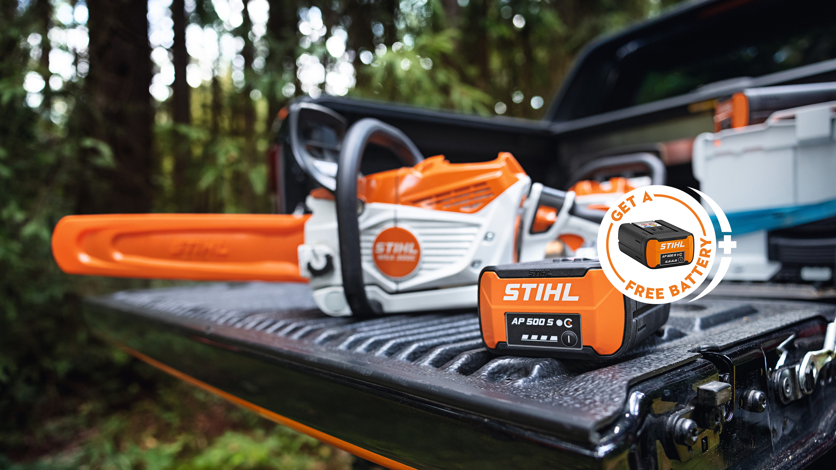 Акумулаторна батерия STIHL AP 500 S върху товарната платформа на пикап заедно с новия акумулаторен моторен трион STIHL MSA 300, допълнителен рекламен елемент с акумулаторна батерия STIHL и надпис „Get a free battery“.