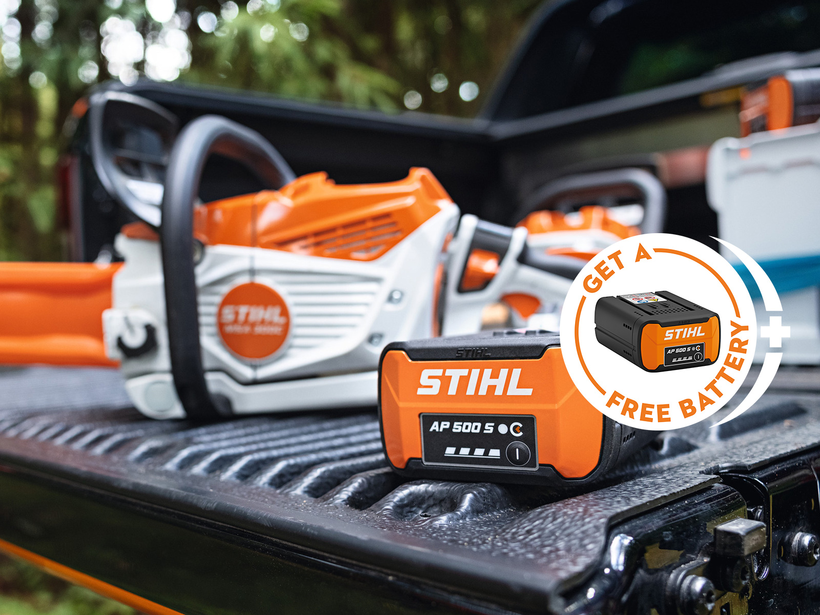 Акумулаторна батерия STIHL AP 500 S върху товарна платформа на пикап заедно с новия акумулаторен верижен трион STIHL MSA 300, допълнително с рекламен елемент с акумулаторна батерия STIHL и надпис „Получи батерия бонус“.