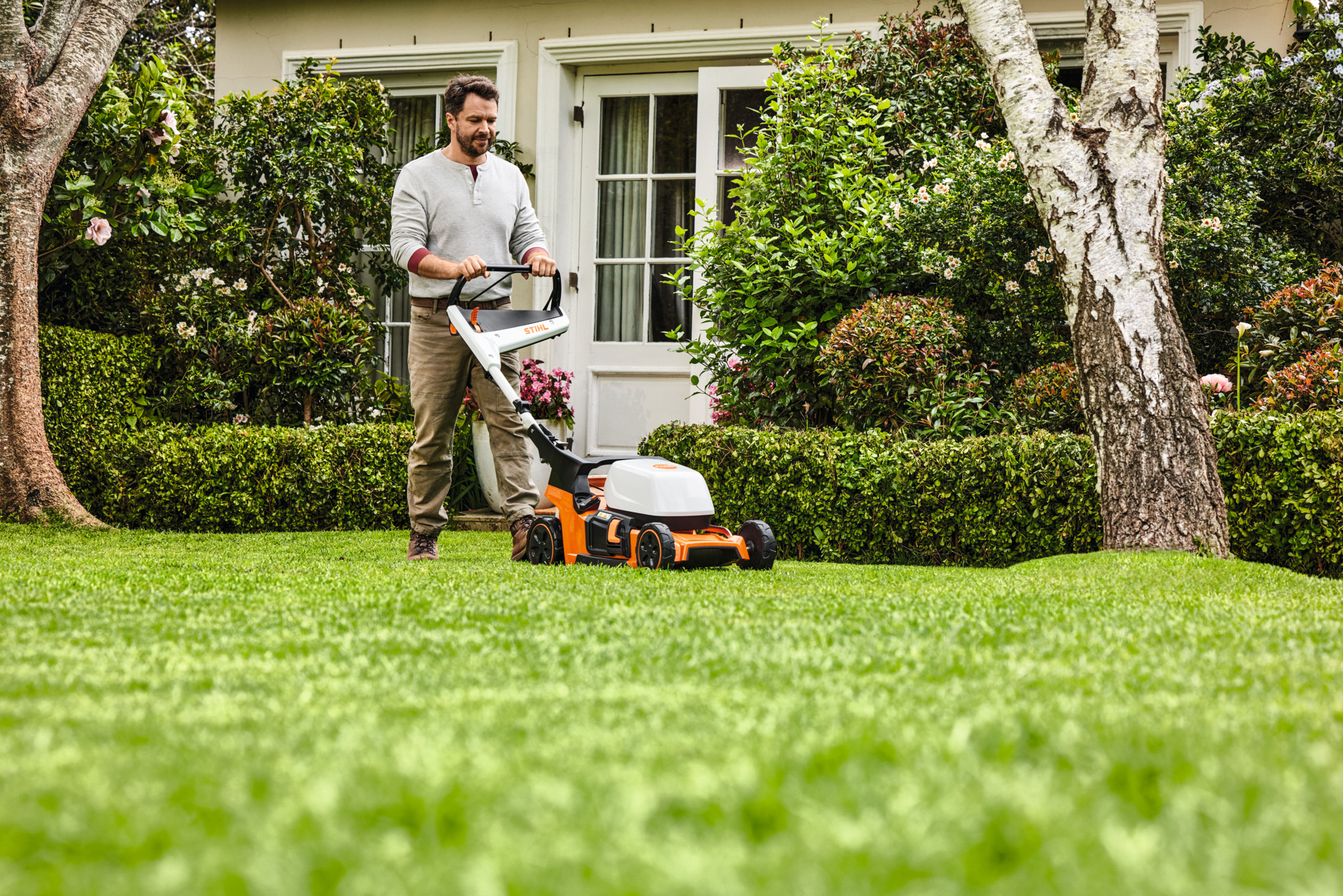 Мъж по време на мулчиране с бензинова косачка за мулчиране STIHL RM 2 R на тревна площ