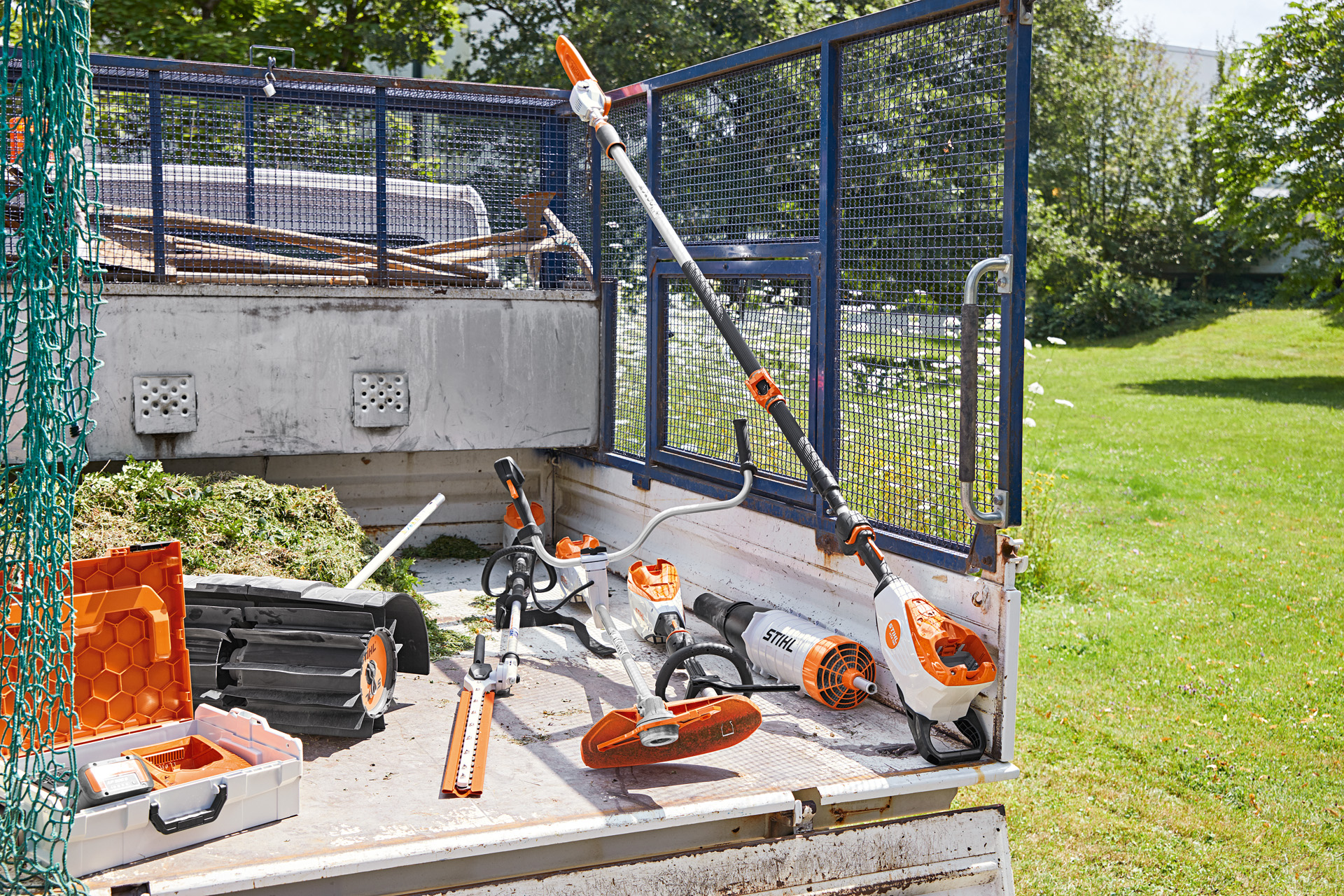 Автомобил с кастрачка STIHL HTA 135, уред за жив плет HLA 135, моторна коса FSA 135 и KMA 135 върху товарната му платформа